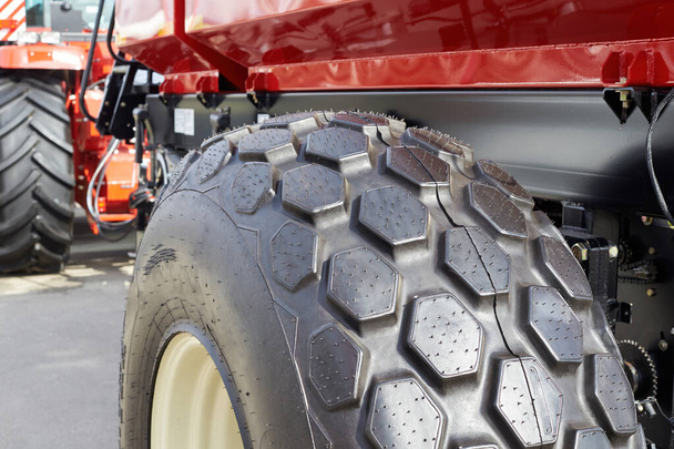 Mezőgazdasági traktor nagy fekete gumikerekeinek közelsége - Fotó, kép