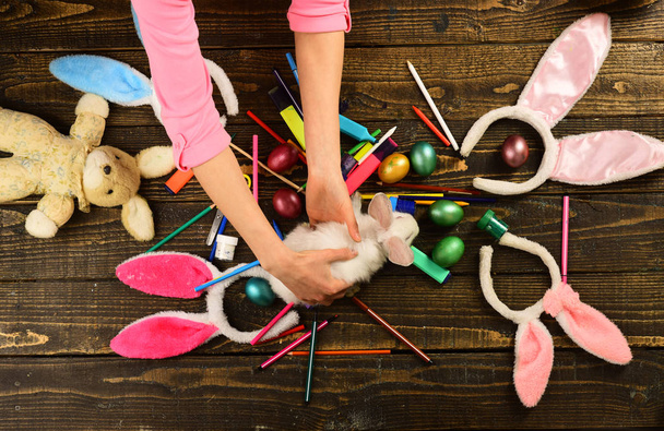 Otec a dítě malují velikonoční vajíčka - pohled shora. Králičí rodina s králičíma ušima. Překvapivé hračky. Ruka s barevnými velikonočními vejci. - Fotografie, Obrázek