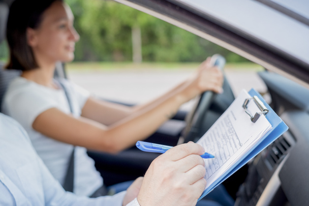 Instructor of driving school giving exam while sitting in car - Foto, immagini