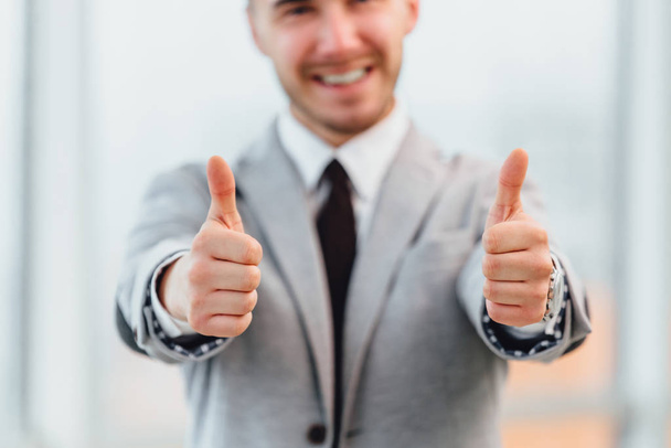 Cropped photo of satisfied businessman showing thumbs up.Focus on the gesture on the forefront. - Foto, immagini