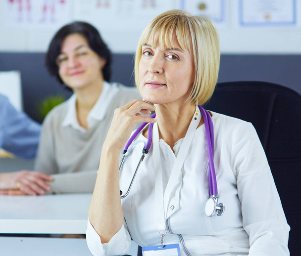Doctor woman sitting with male patient at the desk - Photo, Image