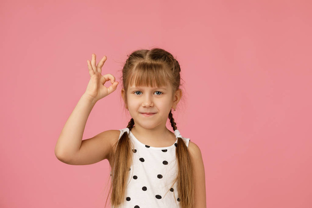 Cute smiling little child girl making Ok gesture - Foto, imagen