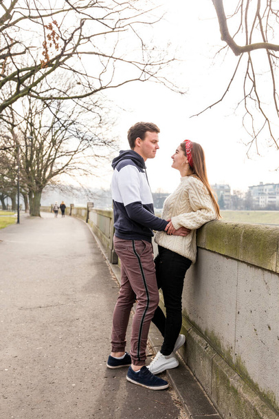 Молодая пара влюблена на открытом воздухе. Милая парочка молодых людей гуляет в весеннем парке. Счастливые парень и девушка
 - Фото, изображение