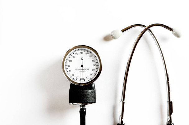 Koncept pro medicínu. Vintage tonometru a stetoskop na bílém pozadí izolované. Pohled shora - Fotografie, Obrázek