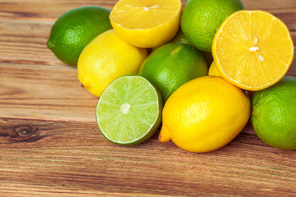 lemons and limes on wooden pad. creative photo. - Foto, afbeelding