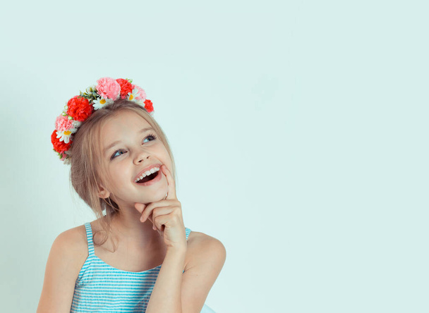 Closeup portrait little Girl thinking daydreaming having idea hand on chin. Closeup portrait of Caucasian kid model with floral headband isolated on white green gray copy space background. - Fotoğraf, Görsel