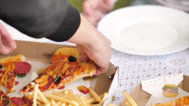 dívka rozdělila feferonkovou pizzu a položila kousek na talíř před dítě - Záběry, video