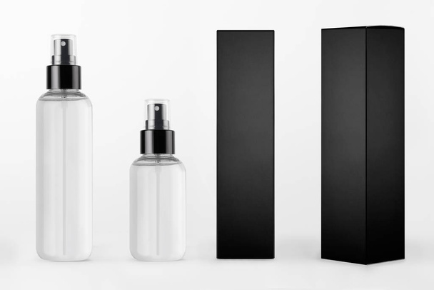 Mock up for design of packing cosmetics - different transparent dispenser bottles and black paper boxes of different sides on white background. - Fotó, kép