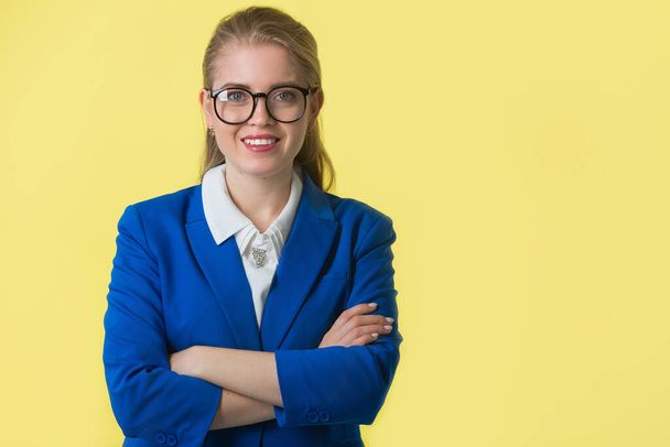beautiful young woman in a blue jacket on a yellow background - Foto, Imagem