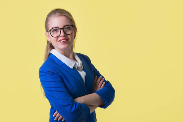 beautiful young woman in a blue jacket on a yellow background - Valokuva, kuva