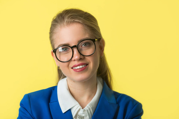 beautiful young woman in a blue jacket on a yellow background - Photo, image