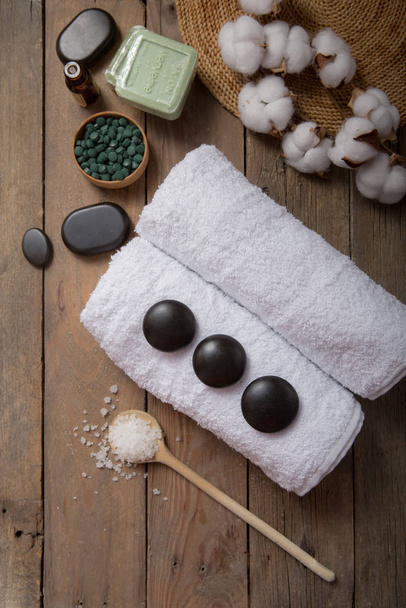 Spa, beauty cosmetics and body care treatment concept with copy space. Creative top view flat lay composition with bath accessories green spirulina, stones, oil, sea salt, soap - Fotó, kép