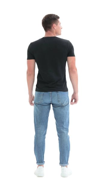 rear view. guy in a black t-shirt staring at a white wall - Foto, afbeelding