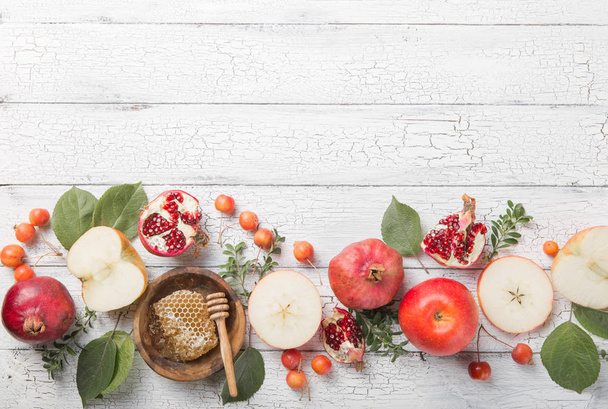 Rosh hashanah - Joods nieuwjaar vakantie concept. Traditionele symbolen: Honingpot en verse appels met granaatappel en shofar -hoorn op een witte achtergrond. Kopieer ruimte voor tekst. Uitzicht van bovenaf - Foto, afbeelding