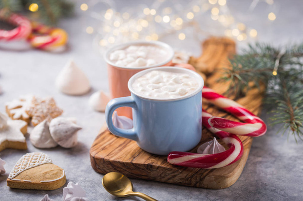 Bebidas de chocolate caliente con malvaviscos en tazas de color navideño sobre fondo gris. Bebida caliente tradicional, cóctel festivo en Navidad o Año Nuevo
 - Foto, Imagen
