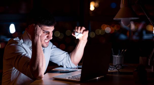 Homme d'affaires en colère à l'ordinateur portable froisser le papier au bureau, Panorama
 - Photo, image