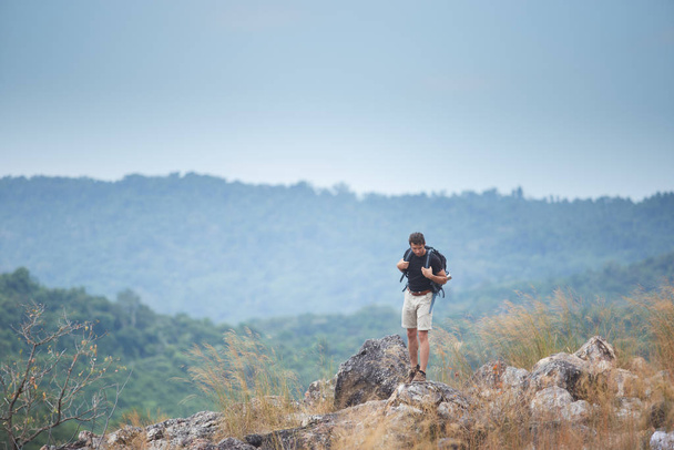 Чоловік-планшет подорожей на природі, стоячи на горі. концепція пішохідної подорожі
. - Фото, зображення