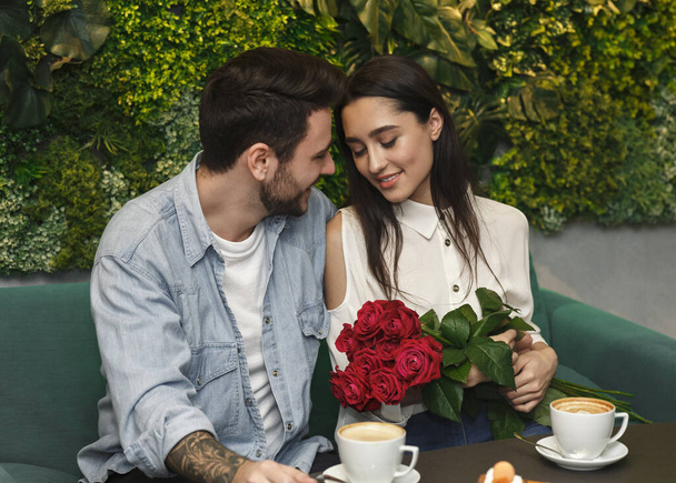 Man Giving Girlfriend Roses Confratulating On Womens Day In Cafe - Foto, Imagen