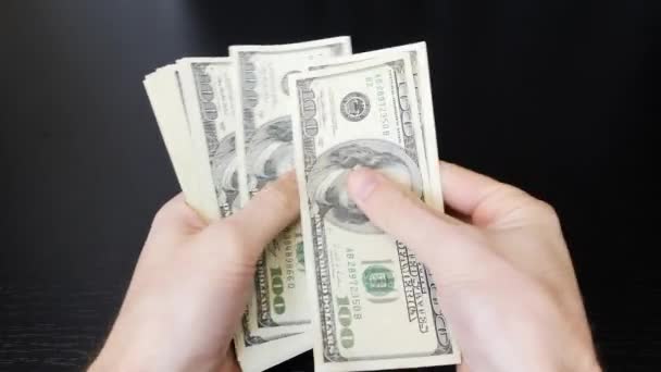 Man counts his salary. Male hands counting american one hundred dollar bills. Paper money pile in hands. Finance and money payment concept. Man counting money cash - Materiał filmowy, wideo