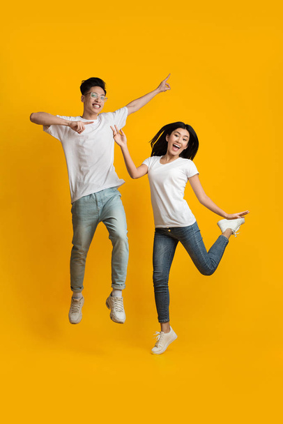 Breezy asian guy and girl jumping in the air - Φωτογραφία, εικόνα