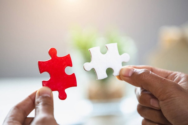 Business women connecting white and red jigsaw puzzles, , cooperation in decision making, team support in solving problems and corporate group teamwork concept. - Photo, Image