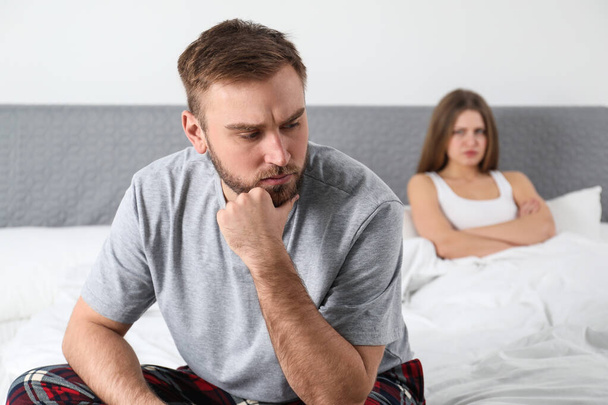 Unhappy couple with relationship problems after quarrel in bedroom - Foto, afbeelding