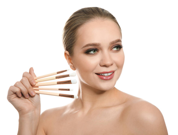 Beautiful woman with makeup brushes on white background - Foto, Imagem