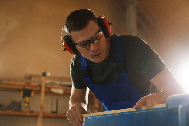 Professional carpenter working with wood in shop - Fotografie, Obrázek