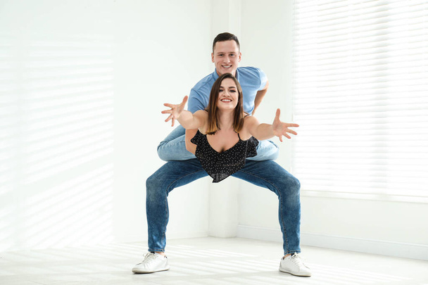 Happy young couple dancing in empty studio - Fotografie, Obrázek