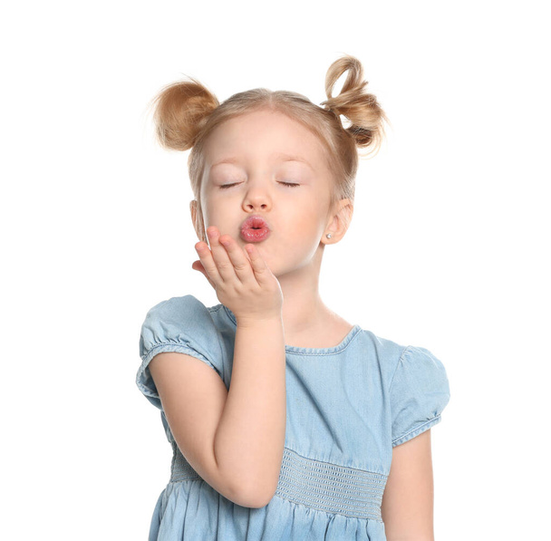Cute little girl blowing air kiss on white background - Foto, imagen