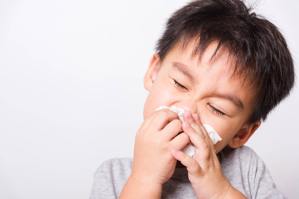 Lähikuva Aasian kasvot, Pienet lapset poika puhdistus nenä kudos valkoisella pohjalla kopioi tilaa, terveydenhuollon
 - Valokuva, kuva