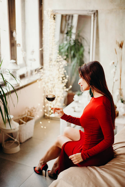 赤ワインのガラスと赤いドレスの女性 - 写真・画像
