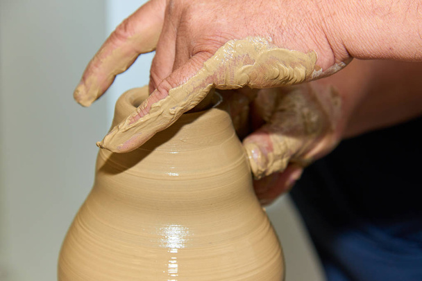 Hands of a potter. Potter making ceramic vase on the pottery wheel. Creating a vase of clay close-up.   - Photo, Image