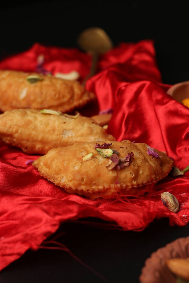Indian Holi snack popuralie bekend als Gujia of Karanji geserveerd op Aardse schotel. (Holi Food Concept) - Foto, afbeelding