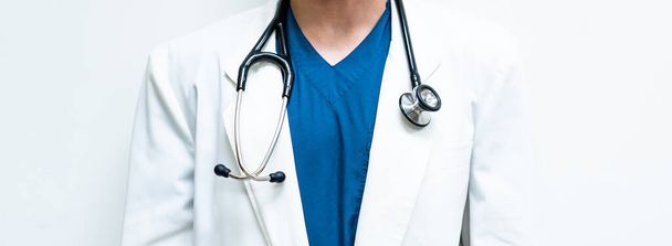 A specialist doctor wearing a blue scrub uniform and white gown and hanging stethoscope around the neck on the white background - Foto, imagen