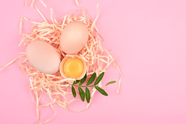 ピンクの背景にイースターのコンセプト。木製のスプーンに卵。白とピンクの背景に卵のトレイ。睾丸とエコトレイ。ミニマルなトレンド、トップビュー。卵盆。イースターのコンセプト - 写真・画像