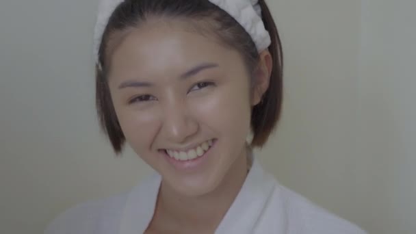 Schönheit junge asiatische Frau bekommen Glück, Smiley-Gesicht. Hübsches asiatisches Mädchen ist ein fröhlicher Mensch, sie ist jedem ein willkommenes Lächeln. Attraktive schöne Frau gerade fertig Bad. Schönes weibliches zahmes Lächeln - Filmmaterial, Video