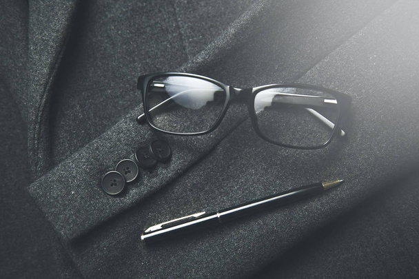 eyeglasses and pen on the coat background - Fotoğraf, Görsel