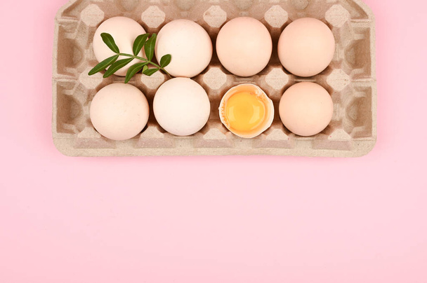 ピンクの背景に卵をエコ。白とピンクの背景に卵のトレイ。睾丸とエコトレイ。ミニマルなトレンド、トップビュー。卵盆。イースターのコンセプト - 写真・画像