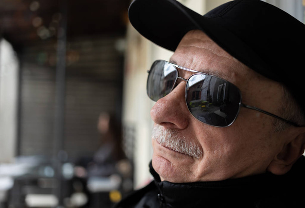 Портрет пожилого человека в профиль в солнечных очках
 - Фото, изображение