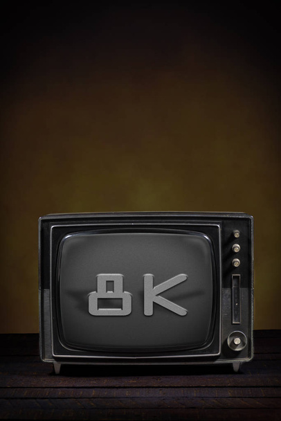 Старый портативный телевизор, с текстом на экране. Деревянный стол и коричневый фон. Концепция устаревания, модернизации или технологической революции
 - Фото, изображение