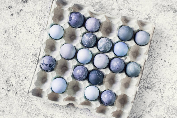 Blue Easter eggs with marble stone effect on grey concrete background. Row of ombre blue Easter eggs. Natural ecological staining with food coloring. Top view. Copy space. - Photo, image