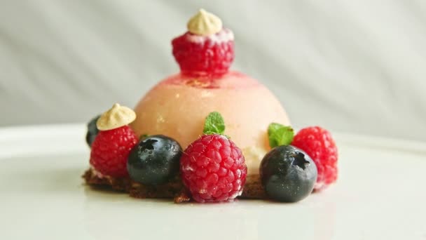 closeup icing dessert exclusive decorated with berries rotates on plate - Materiał filmowy, wideo