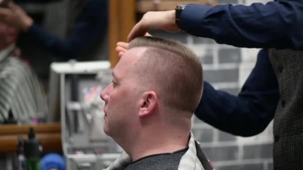 Corte de pelo para hombre en la barbería. Primer plano del maestro terminando el peinado del cabello
 - Imágenes, Vídeo