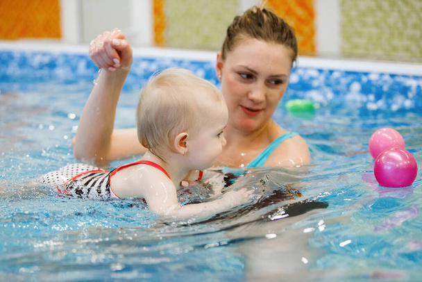 Donna bambino allenatore e bambino nuotare e studiare in piscina d'acqua blu
 - Foto, immagini