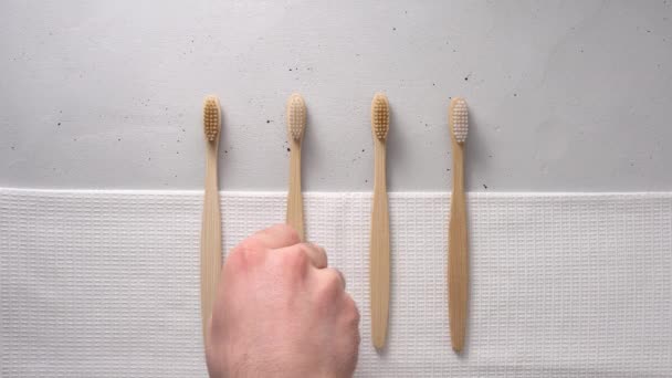 Een mannelijke hand neemt een bamboe tandenborstel. - Video