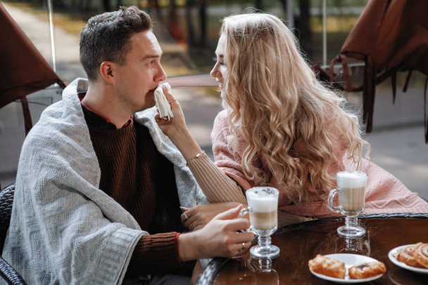 Deux amants, un homme et une femme à une table dans un café. Câlin, caresse, boisson latte. Joyeux couple traditionnel, bonheur familial
. - Photo, image
