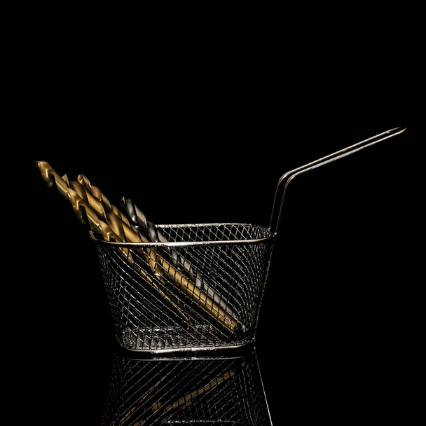 Drills in a shopping basket on a black background. Isolate on a black background. - Foto, Imagem