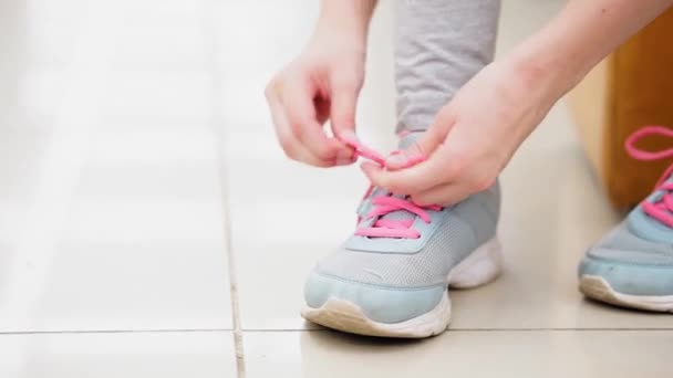 Girl tying pink shoelaces on sneakers. - Felvétel, videó