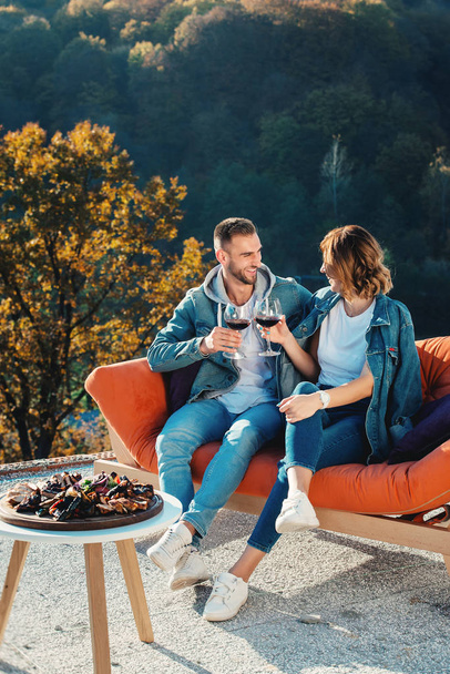 jovem casal comemorando a compra de uma nova casa. Marido e esposa sorridentes com copos de vinho tinto nas mãos
 - Foto, Imagem